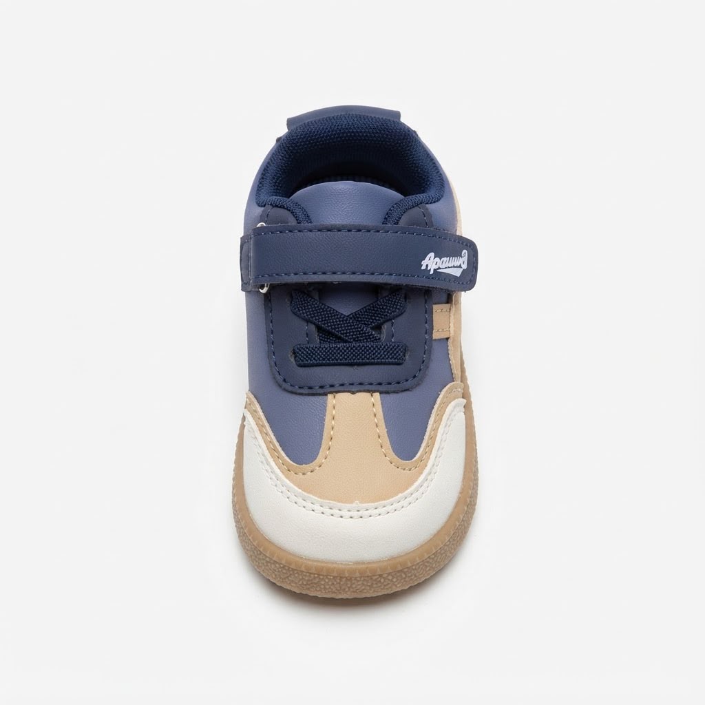 A single toddler's low-top sneaker shown from a front-facing perspective on a light gray background. The shoe features navy blue panels, a beige suede-like toe section, a white rubber toe bumper, and a brown gum sole.