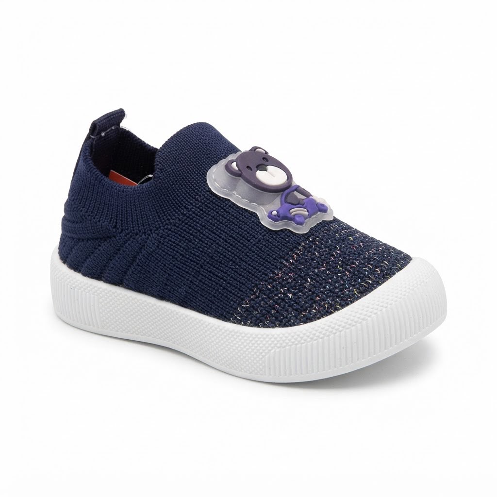 A navy blue knit slip-on shoe for toddlers, featuring a white textured sole and a purple bear-shaped plastic buckle closure on the side.