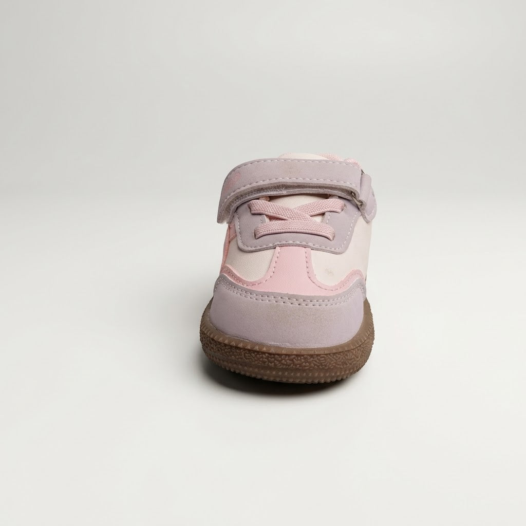 A single toddler sneaker shown from the front, featuring a light purple suede upper with pink panels, a hook-and-loop strap closure, and a brown textured sole, set against a plain light gray background.