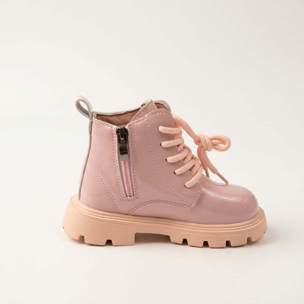 A single light pink lace-up ankle boot with a side zipper, glossy patent finish, and chunky lug sole, shown on a clean off-white background.