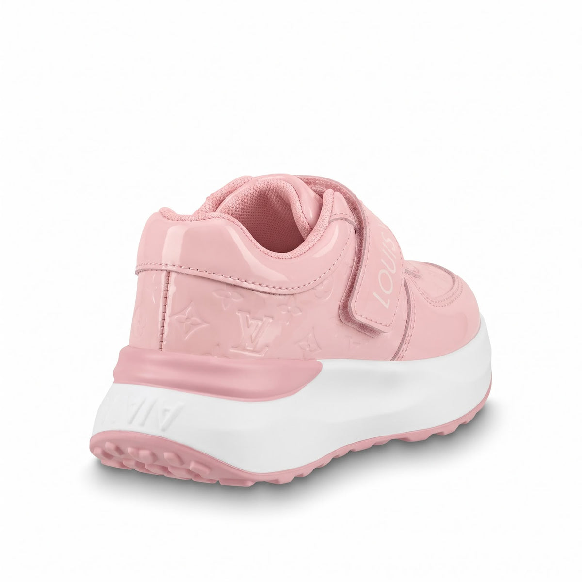 A light pink sneaker with a glossy patent finish, embossed monogram pattern, hook-and-loop strap, and a chunky white  midsole with pink outsole details, shown from a three-quarters rear angle on a white background.
