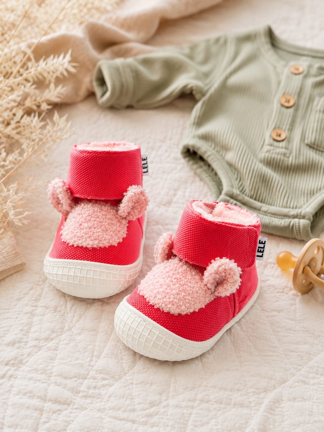 Cute red high-top baby first-walker shoes with fluffy pink teddy ears, secure velcro strap, and white non-slip rubber sole.