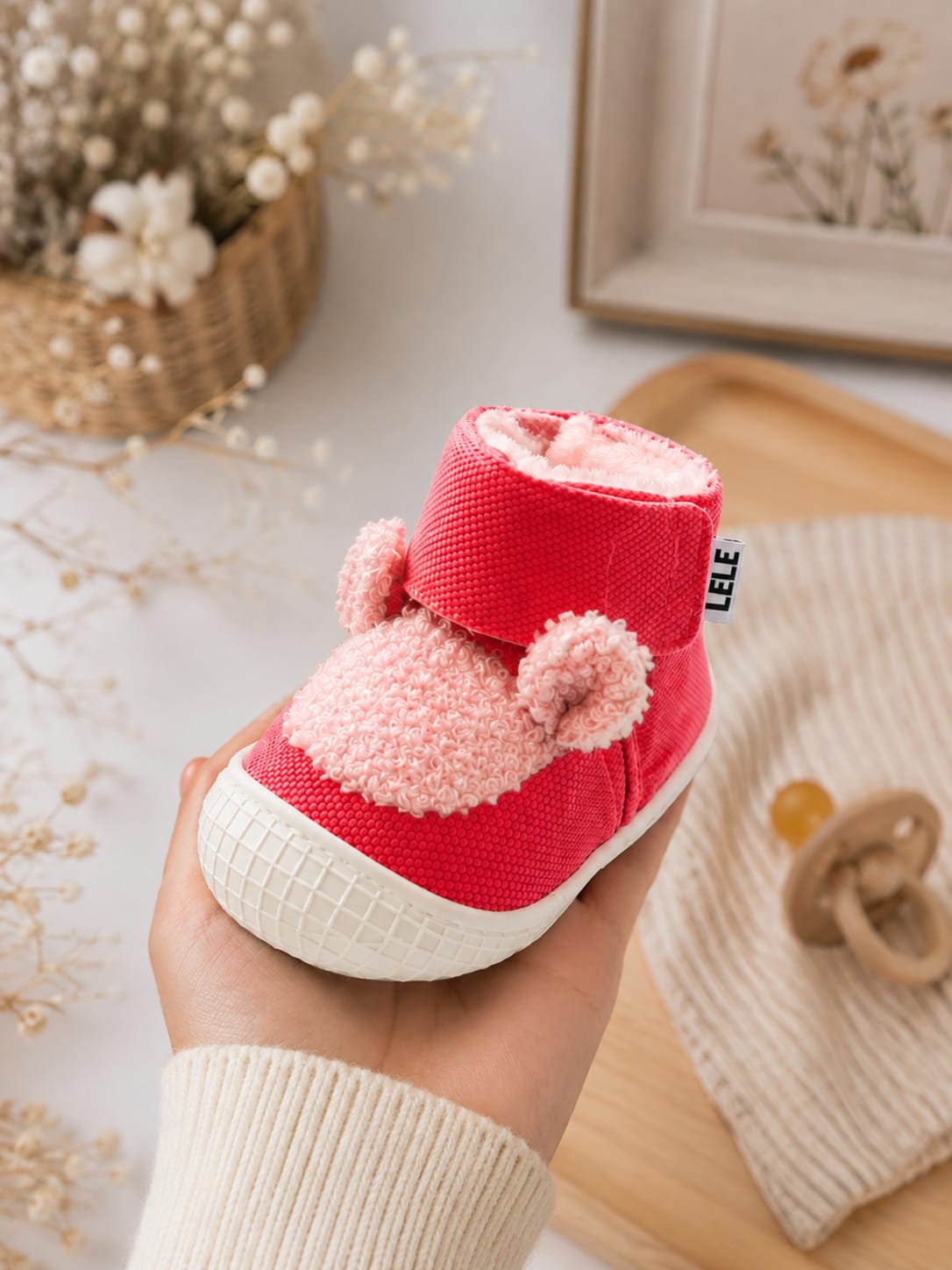 Cute red high-top baby first-walker shoes with fluffy pink teddy ears, secure velcro strap, and white non-slip rubber sole.