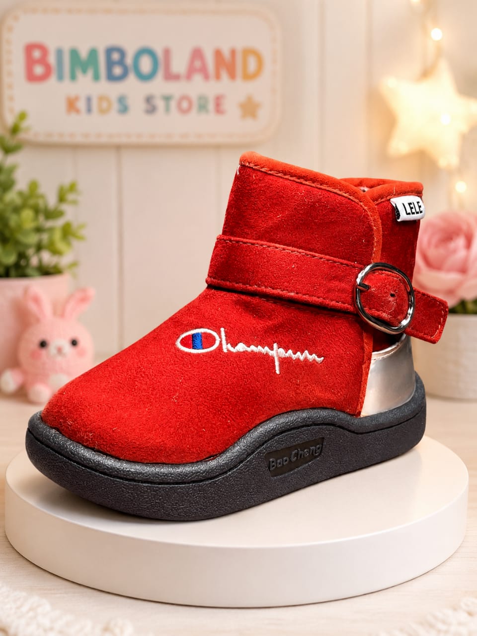 Red suede ankle boots for kids with fur lining, buckle strap, and chunky black sole