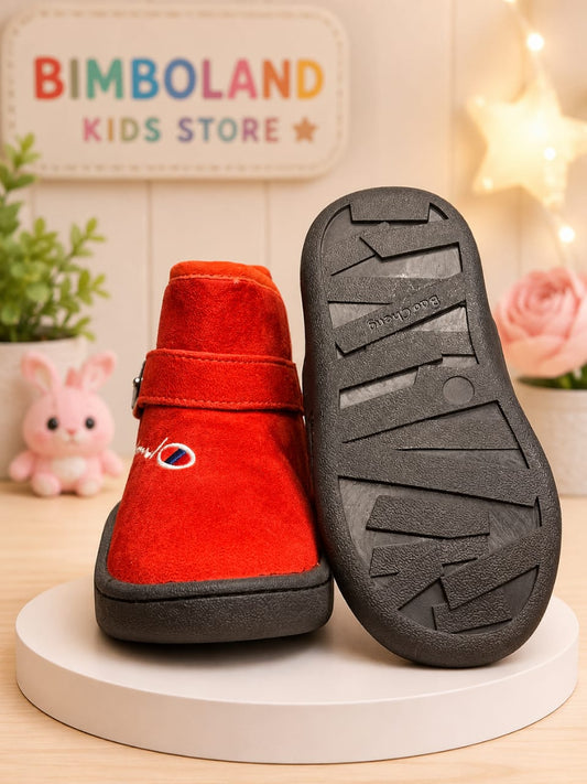 Red suede ankle boots for kids with fur lining, buckle strap, and chunky black sole